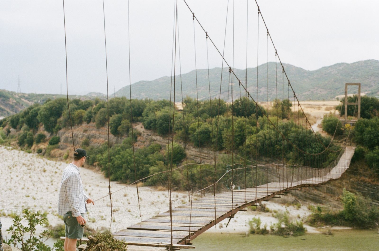 A hiker before crossing a bridge on a scenic view in Albania