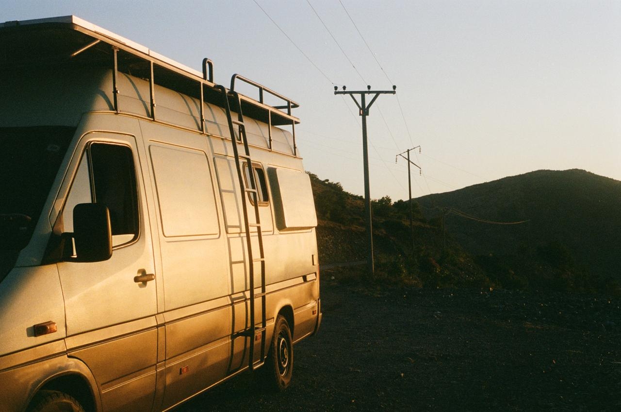 A campervan parked in a scenic location during sunset